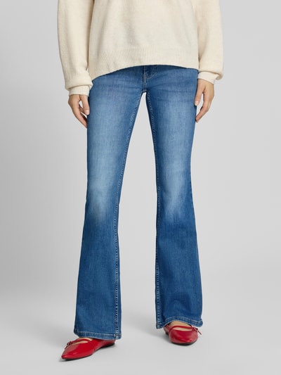 Vrouwenmodel draagt Flared Jeans met middelhoge band in middelblauwe wassing van REVIEW, mix van biologisch katoen, flared fit, knoop- en ritssluiting, 5-pocketmodel, bandwijdte maat 27: 34 cm, binnenbeenlengte maat 27: 81 cm. Ganzkörperansicht van voren.