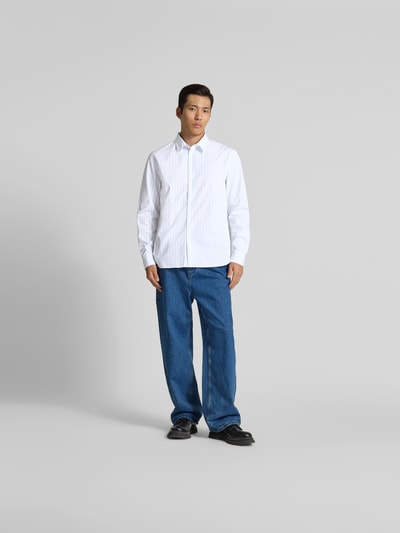 Männermodel trägt Slim Fit Freizeithemd aus Baumwolle von MAISON KITSUNÉ, weiß mit feinem Muster, Kentkragen, Ganzkörperansicht von vorne. Rückenlänge bei Größe M: 77 cm, Schulterbreite 43 cm, Ärmellänge 66 cm, durchgehende Knopfleiste, langärmeliges Design.