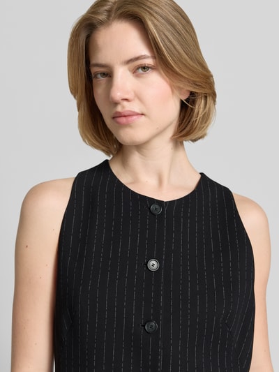 Kobiece modelka nosi kamizelkę Slim Fit Weste aus reiner Viskose Modell 'JULERAN' od BOSS, wzór w cienkie prążki, materiał: wiskoza, efekt: wzór na całej powierzchni, aplikacja z metką, listwa guzikowa, kieszenie z wypustkami, kolor czarny, faktura gładka, zapięcie: listwa z 3 guzikami, rozporek, Nahaufnahme Oberkörper.