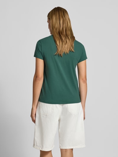 Frauenmodel trägt Regular Fit T-Shirt aus reiner Baumwolle von Levi's® in Dunkelgrün zu weißer Shorts, Ganzkörperansicht Rückansicht.
