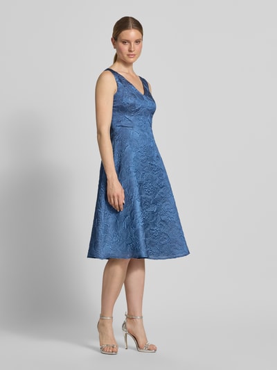 Frauenmodel trägt Cocktailkleid mit Strukturmuster und V-Ausschnitt von Vera Mont in Blau, A-Linie, Midikleid; Ganzkörperansicht von vorne.