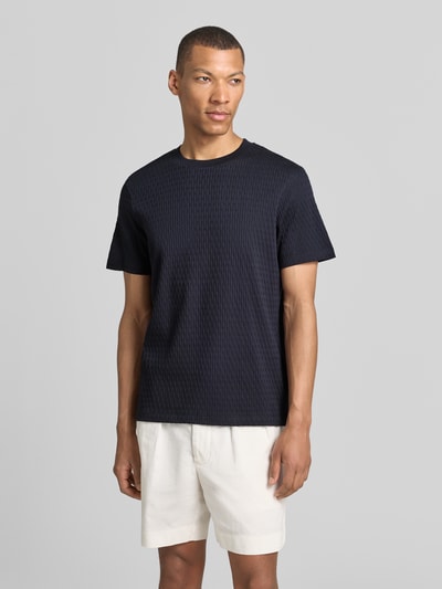 Männermodel trägt T-Shirt mit Strukturmuster Modell 'Raulos' von JOOP! Collection aus Reine Baumwolle, Modern Fit, Nahaufnahme Oberkörper.