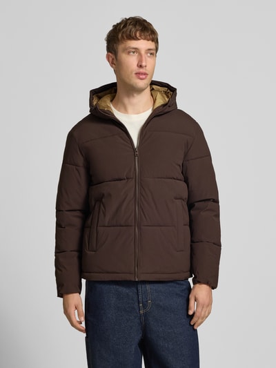 Mannelijk model draagt gewatteerd jack met capuchon Model 'GALAXY' van JACK & JONES in bruin, steekzakken, regular fit, ritssluiting, ganzekijk van voren. Ruglengte maat M: 70 cm, schouderbreedte: 49 cm, borstwijdte: 58 cm, mouwlengte: 69 cm.