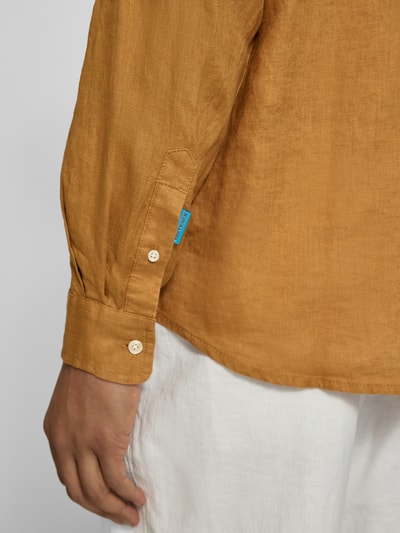 Männermodel trägt Regular Fit Leinenhemd mit Kentkragen von Scotch & Soda, zuiver linnen, knoopsluiting, detailaufnahme linker onderarm