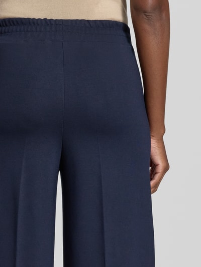 Frauenmodel trägt Straight Fit Hose aus Viskose-Mix mit Bügelfalten von MORE, dunkelblau, strukturierte Oberfläche, Nahaufnahme Rückansicht.