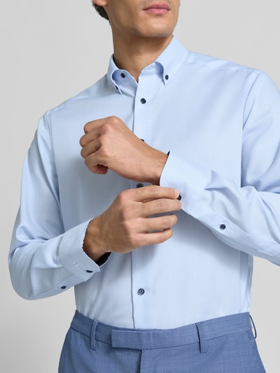 Männermodel trägt Modern Fit Businesshemd aus reiner Baumwolle von OLYMP in Hellblau, glatte Textur, Nahaufnahme Oberkörper, Herren Businesshemd von OLYMP.