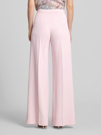 Frauenmodel trägt Stoffhose mit Bügelfalte von Rinascimento in zartem Rosa, Wide Leg Fit, strukturierte Oberfläche, Ganzkörperansicht Rückansicht.