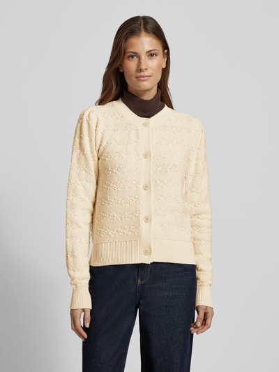 Vrouwenmodel draagt Strickjacke mit Rundhalsausschnitt van Scotch & Soda, beige katoenmix, regular fit, knoopsluiting, voorkant, bovenlichaam close-up.