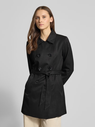 Frauenmodel trägt Regular Fit Trenchcoat mit doppelreihiger Knopfleiste Modell 'VALERIE' von Only, unifarben schwarz, Umlegekragen, mit Taillengürtel, seitliche Eingrifftaschen, Nahaufnahme Oberkörper.