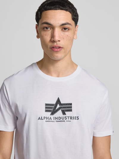 Männermodel trägt Herren T-Shirt aus Reine Baumwolle von Alpha Industries, Modell 'BASIC' mit Label-Details, Nahaufnahme Oberkörper.