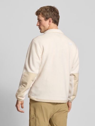 Männermodel trägt Fleecejacke mit Napoleontasche Modell 'YUMIORI' von The North Face, beige, strukturierte Oberfläche, Ganzkörperansicht Rückansicht, gerade Passform, elastische Abschlüsse.