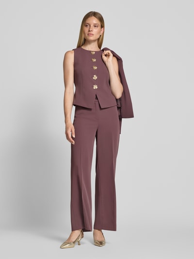 Frauenmodel trägt Weste mit Rundhalsausschnitt und Knopfleiste von Christian Berg Woman Selection im Material-Mix mit Stretch-Anteil, taillierter Schnitt, warme violette Farbe, glatte Textur, Ganzkörperansicht von vorne. Rückenlänge bei Größe 36: 50 cm, Schulterbreite: 31 cm, Brustweite: 33 cm.