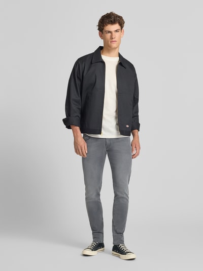 Männermodel trägt Slim Fit Jeans mit Eingrifftaschen Modell 'ANBASS' von Replay, grauer Baumwoll-Elasthan-Mix, Ganzkörperansicht von vorne, Herren, Slim-Fit, Größe 32/32, Bundweite 42 cm, Innenbeinlänge 80 cm.