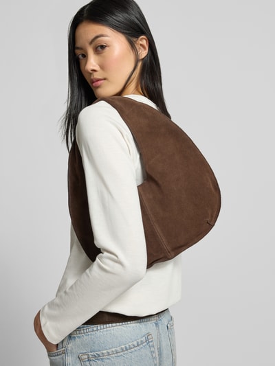 Frauenmodel trägt Hobo Bag aus echtem Leder Modell 'Sack Bag' von MANGO, dunkelbraun, offene Struktur, kurze Schulterriemen, Ganzkörperansicht Rückansicht.