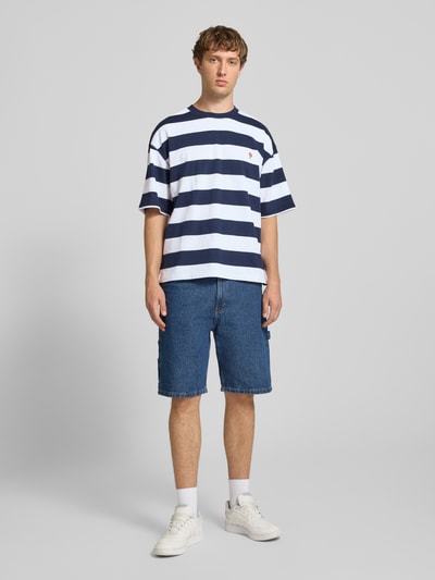 Männermodel trägt T-Shirt mit Label-Stitching und Rundhalsausschnitt von REVIEW, Herren T-Shirt aus Reine Baumwolle, Relaxed-Fit, Allover-Look, Rückenlänge bei Größe M 67 cm, Querstreifen in Blau und Weiß, Ganzkörperansicht von vorne.