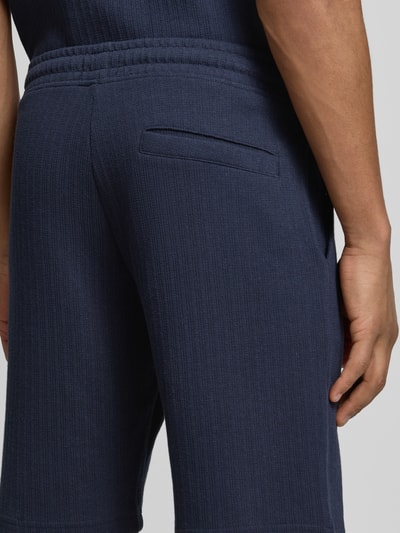 Männermodel trägt Regular Fit Shorts mit Tunnelzug von MCNEAL aus dunkelblauem Baumwoll-Mix mit Stretch-Anteil, Detailaufnahme Rückansicht.