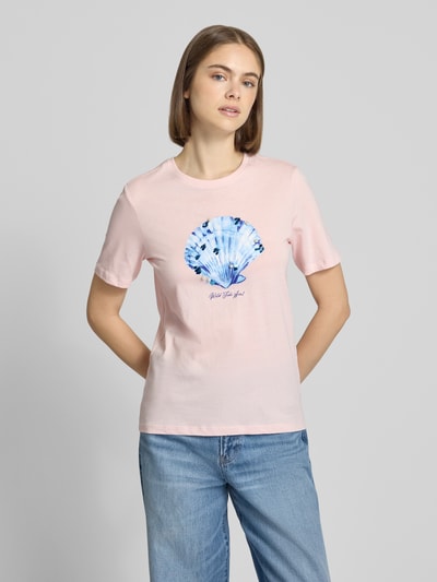 Frauenmodel trägt Regular Fit T-Shirt aus reiner Baumwolle Modell 'KITA' von Only, Optik: Unifarben in Rosa, Motiv-Print mit Pailletten, Perlen und Glitzer-Print, Rundhals, Kurzarm, Materialverarbeitung: Jersey, aus reiner Bio-Baumwolle, Ganzkörperansicht von vorne.