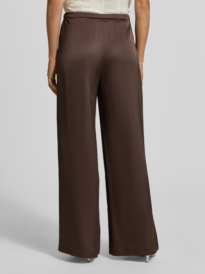 Frauenmodel trägt Wide Fit Stoffhose mit Viskose-Anteil von comma, braun, Satin-Optik, elastischer Bund, Ganzkörperansicht Rückansicht.