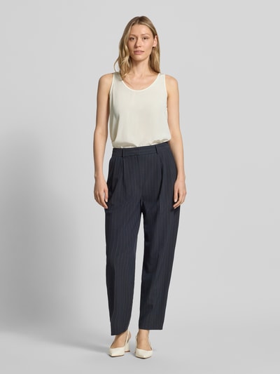 Kobiece modelka nosi Blusenshirt mit Rundhalsausschnitt und Label-Detail od Marc Cain, satyna, krój straight fit, okrągły dekolt, detal z logo, długość tyłu w rozmiarze 36: 52 cm, ujęcie całej sylwetki z przodu