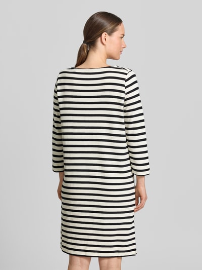 Frauenmodel trägt Loose Fit Freizeitkleid aus reiner Baumwolle von Marc O'Polo in Schwarz und Weiß, Querstreifen, Ganzkörperansicht Rückansicht.