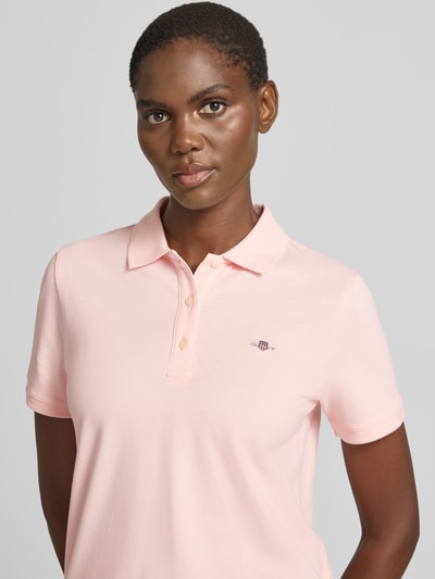 Frauenmodel trägt Poloshirt mit Logo-Stitching und Polokragen von Gant aus Reine Baumwolle, Regular-Fit, Kurze Knopfleiste, Nahaufnahme Oberkörper.