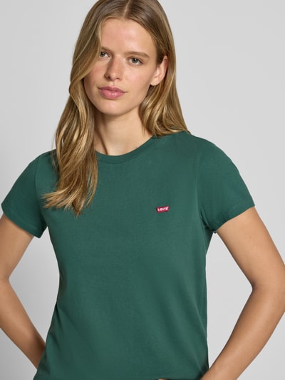 Frauenmodel trägt Regular Fit T-Shirt aus reiner Baumwolle von Levi's®, dunkelgrün, glatte Textur, Nahaufnahme Oberkörper, Damen T-Shirt von Levi's®.