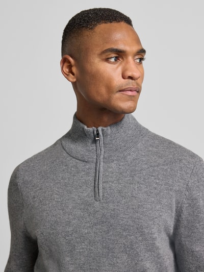 Męski model nosi Regular Fit troyer z mieszanki żywej wełny i kaszmiru Model 'HEMARLO' od BOSS, efekt: jednolity kolor, drobny splot, naszywka z logo, Kołnierz zapinany, krótki zamek błyskawiczny, długi rękaw, prążkowane wykończenia. Nahaufnahme Oberkörper.