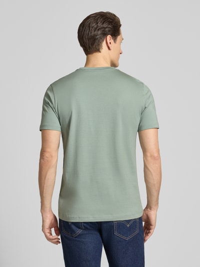 Männermodel trägt Regular Fit T-Shirt mit Logo-Print von Christian Berg Men, grün, reine Baumwolle, Rückansicht, Ganzkörperansicht.