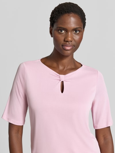 Modelka kobieca ma na sobie damski t-shirt z mieszanki modalu marki MORE & MORE, taliowany krój, dekolt w serek z wycięciem w kształcie łezki, design z rękawem o dł. 1/2, długość tyłu w rozmiarze 36: 59 cm, jasnoróżowy kolor, gładka faktura, widok na górną część sylwetki, z przodu.