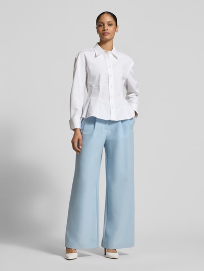 Frauenmodel trägt Wide Fit Stoffhose mit Viskose-Anteil von Jake*s Collection in Hellblau mit Bundfalten und Gesäßtaschen, Ganzkörperansicht von vorne.