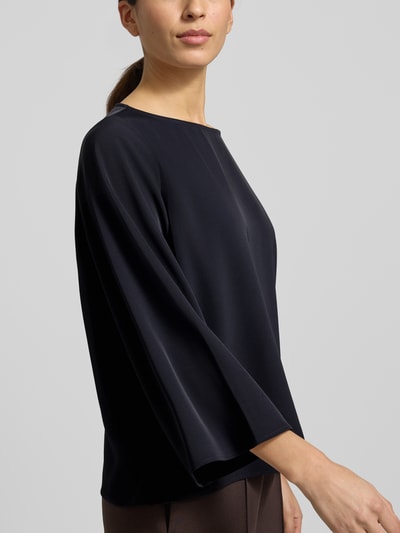 Modelka nosi Blusenshirt mit Rundhalsausschnitt von comma, czarny materiał-mix z elastycznym dodatkiem, luźny krój, długość tyłu 59 cm, długość rękawa 52 cm, zbliżenie na górną część ciała z przodu