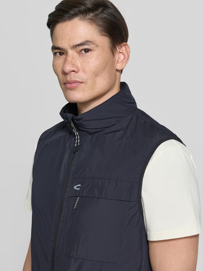 Männermodel trägt Regular Fit Weste mit gefüttertem Stehkragen von camel active in Dunkelblau, mit Brusttasche, Reißverschluss, Eingrifftaschen, elastischer Bund, Nahaufnahme Oberkörper. Rückenlänge 64 cm, Schulterbreite 45 cm, Brustweite 60 cm.