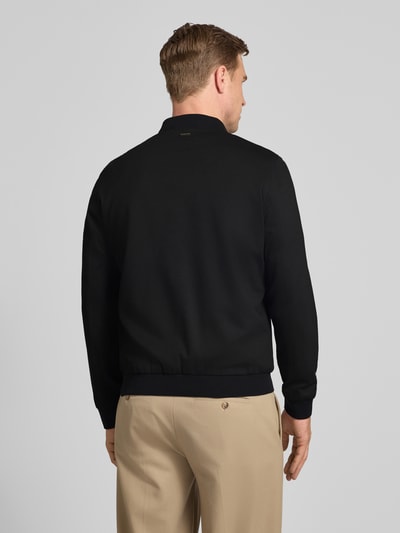 Männermodel trägt Bomberjacke mit Zweiwege-Reißverschluss von Roy Robson, Schwarz, Material-Mix mit Stretch-Anteil, Regular-Fit, Stehkragen, Rückenlänge 68 cm, Schulterbreite 49 cm, Brustweite 52 cm, Ärmellänge 68 cm, Ganzkörperansicht Rückansicht.