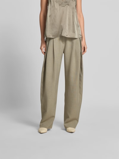 Frauenmodel trägt Wide Fit Stoffhose mit Bundfalten von Iro in Beige mit Eingrifftaschen, Gesäßtaschen, Haken- und Reißverschluss, Ganzkörperansicht von vorne.