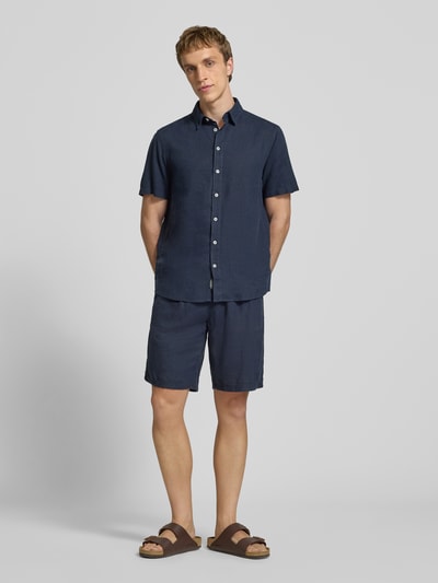 Männermodel trägt dunkelblaues Slim-Fit Leinenhemd mit Viskose-Anteil Modell 'Bobby' von Blend, Kentkragen, Kurzärmelig, Knopfleiste, Ganzkörperansicht von vorne, Rückenlänge 75 cm, Schulterbreite 38 cm, Ärmellänge 23 cm.