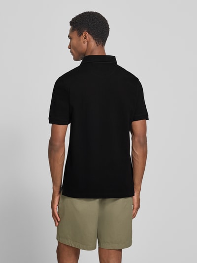 Männermodel trägt Regular Fit Poloshirt aus reiner Baumwolle von s.Oliver RED LABEL in Schwarz, glatte Textur, Ganzkörperansicht Rückansicht.