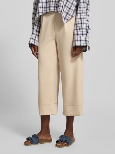 Frauenmodel trägt Wide Leg Sweatpants mit Eingrifftaschen von Rich & Royal in Beige, elastischer Bund, Modal-Mix mit Stretch, Nahaufnahme Unterkörper.