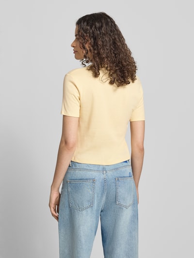 Kobiece modelka nosi damski t-shirt z okrągłym dekoltem od Topshop, bawełna, taliowany krój, krój krótki, długość tyłu w rozmiarze S 47 cm, jasny żółty, gładka faktura, pełny widok z tyłu