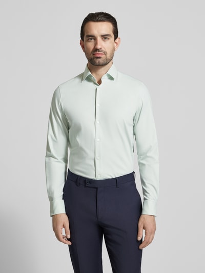 Männermodel trägt Slim Fit Business-Hemd mit Kentkragen von OLYMP Level Five in Hellgrün; glatte Struktur, Knopfleiste, Ganzkörperansicht von vorne; elastischer Baumwoll-Mix, schmaler Schnitt, Business-Look.