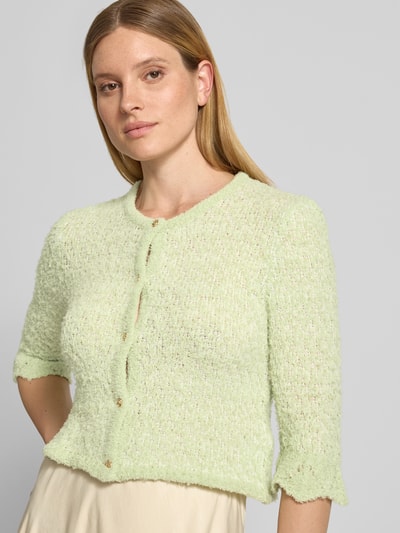 Frauenmodel trägt Strickjacke aus Lanawolle-Mix mit 3/4-Arm von Christian Berg Woman, Stretch-Anteil, Slim-Fit, Rundhalsausschnitt, Knopfleiste, helle Pastellfarbe, weiche Struktur, Nahaufnahme Oberkörper.