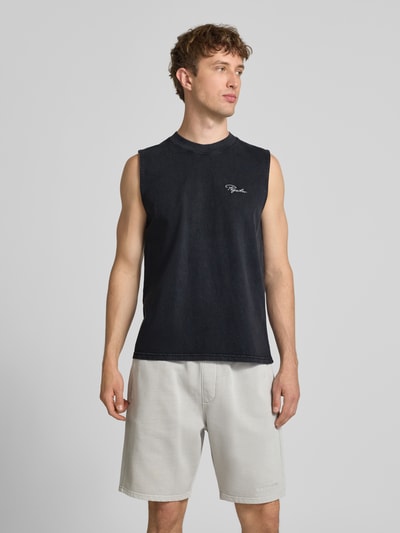 Männermodel trägt Tanktop mit Label-Stitching und Rundhalsausschnitt von Pegador in Schwarz aus Reine Baumwolle, Relaxed-Fit, Ganzkörperansicht von vorne. Rückenlänge bei Größe M: 66 cm.