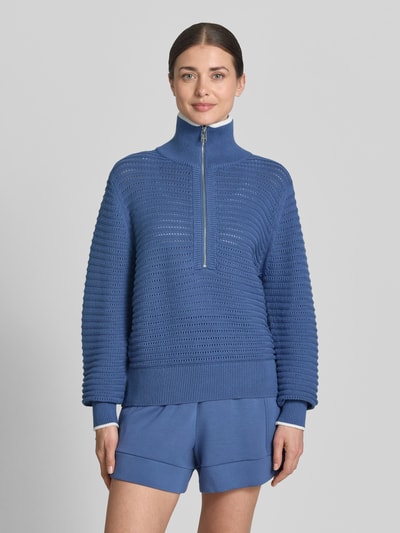 Frauenmodel trägt Strickpullover mit Reißverschluss Modell 'morwenna' von VARLEY in Blau, Reine Baumwolle, Regular-Fit, Stehkragen, Ganzkörperansicht von vorne.