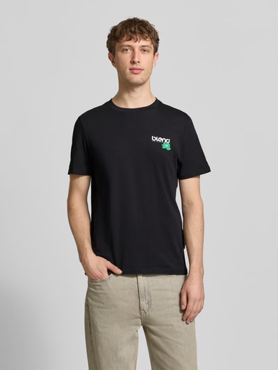 Männermodel trägt Regular Fit T-Shirt mit Logo-Print Modell 'Kenan' von Blend aus reiner Baumwolle, Rundhalsausschnitt, Ganzkörperansicht von vorne.