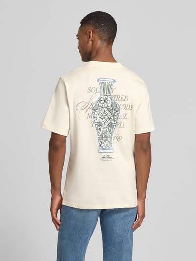 Männermodel trägt T-Shirt mit rückseitigem Motiv-Print Modell 'Ben Faience' von Les Deux aus reiner Baumwolle, cremefarben, gerader Schnitt, Rundhalsausschnitt, Statement-Print, Label-Detail, Rückenlänge w rozmiarze M: 70 cm, Ganzkörperansicht Rückansicht