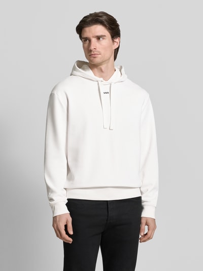 Männermodel trägt Regular Fit Hoodie aus reiner Baumwolle Modell 'DAPO' von HUGO, unifarben, Langarm, Kapuze, Label-Schriftzug, Nahaufnahme Oberkörper.