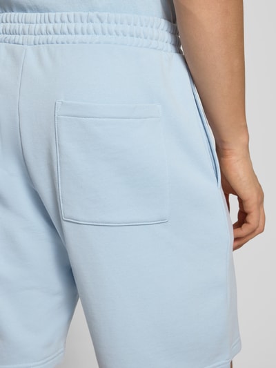 Männermodel trägt Regular Fit Shorts mit Label-Stitching von REVIEW in Hellblau, Baumwoll-Mix, elastischer Bund, Detailaufnahme Rückansicht.