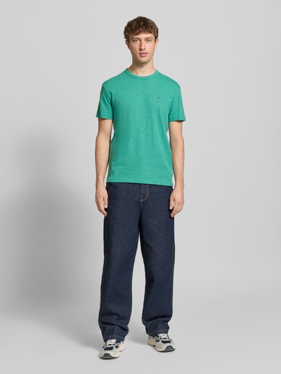Männermodel trägt Regular Fit T-Shirt aus reiner Baumwolle von Tommy Jeans in Optik: Unifarben, Rundhals, Kurzarm, Jersey, Ganzkörperansicht von vorne.