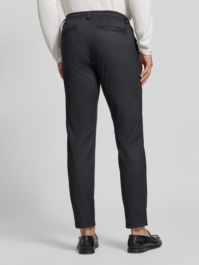 Männermodel trägt Tapered Fit Jogpants mit Viskose-Anteil Modell 'Phil' von Brax, anthrazitfarben, glatte Textur, Ganzkörperansicht Rückansicht, Herren Weite Hose