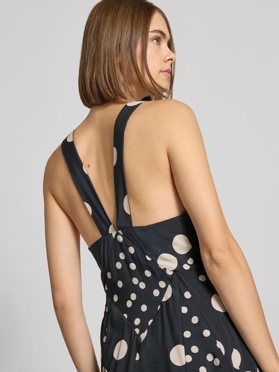 Frauenmodel trägt Maxikleid aus Viskose-Mix Modell 'Inge' von Topshop mit Punkten in Schwarz und Beige, tailliert, Rückenansicht, Nahaufnahme Oberkörper.