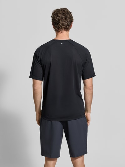 Männermodel trägt Herren T-Shirt mit Logo- und Motiv-Print Modell 'Kout' von Salomon in Schwarz, Gerader-Schnitt, Rückenlänge 70 cm, Ganzkörperansicht Rückansicht.